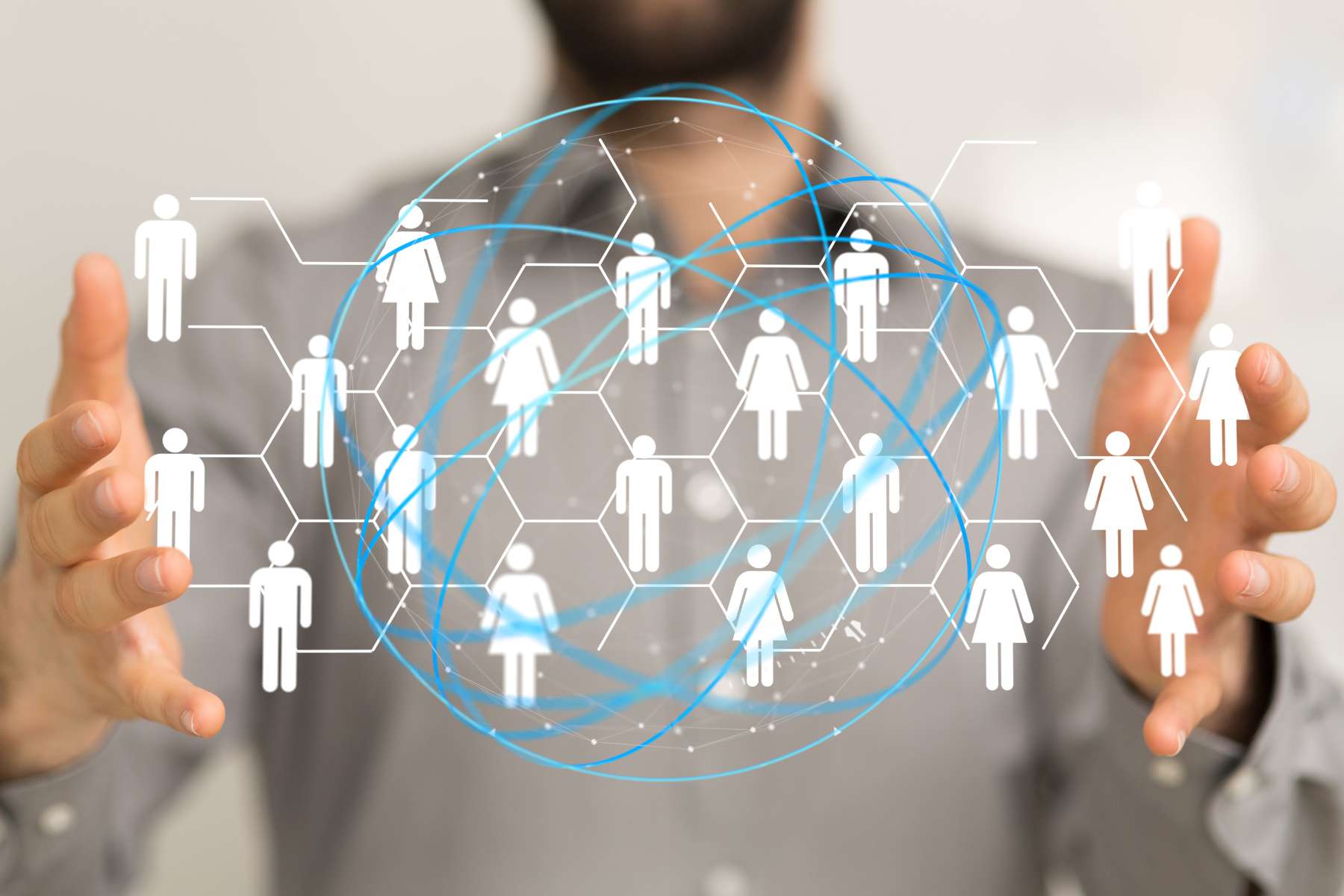 Ein Mann in grauem Hemd, verschwommen im Hintergrund zu sehen, hält ein digitales Bild zwischen den Händen, auf dem mehrere Personen silhouettenhaft abgebildet und miteinander verbunden sind, als Sinnbild für Algorithmic Management im Büro.