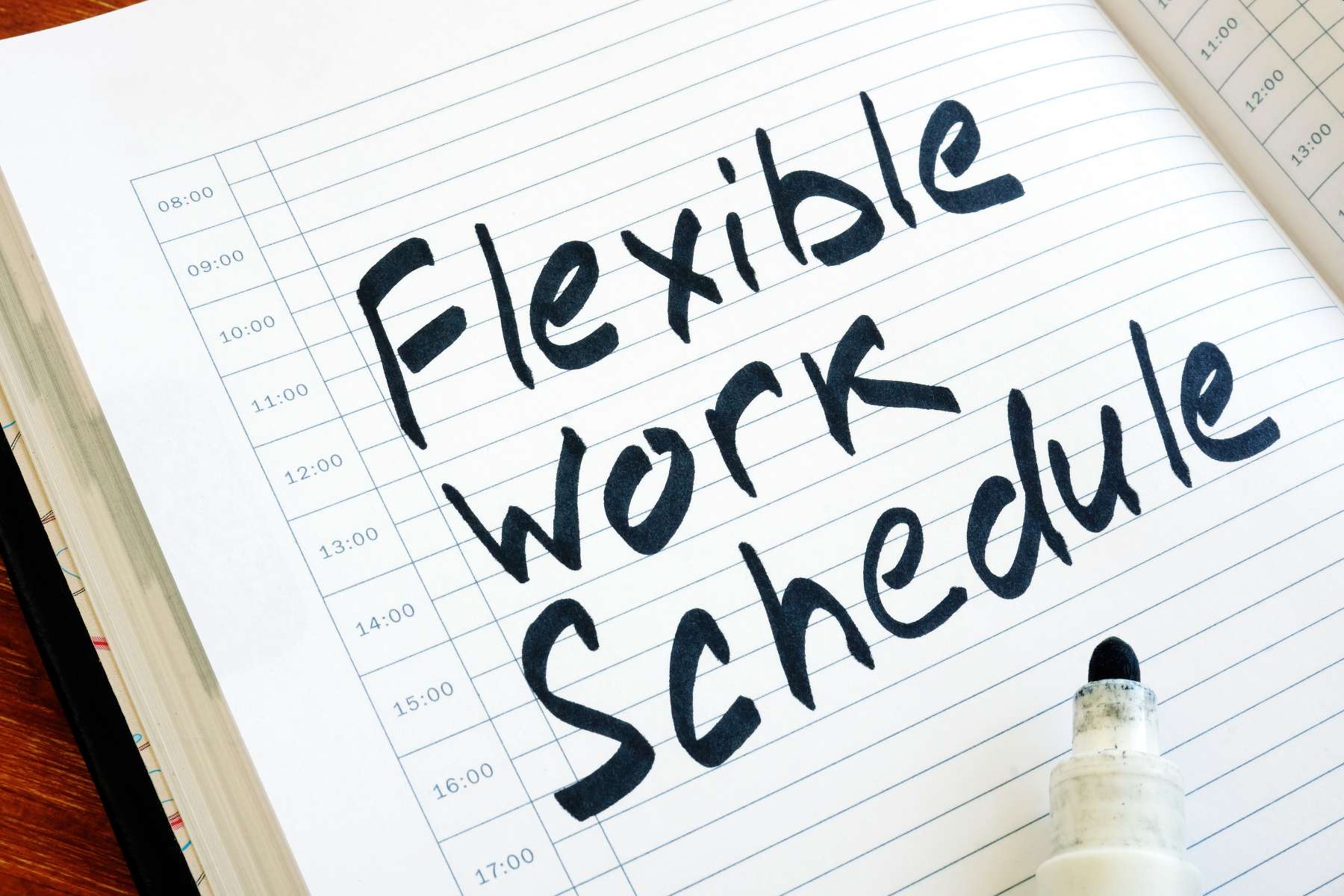 Nahaufnahme eines weißen Terminkalenders in den mit großer schwarzer Schrift die Wörter Flexible Work Schedule geschrieben sind als Hinweis auf das Thema Arbeitszeit.