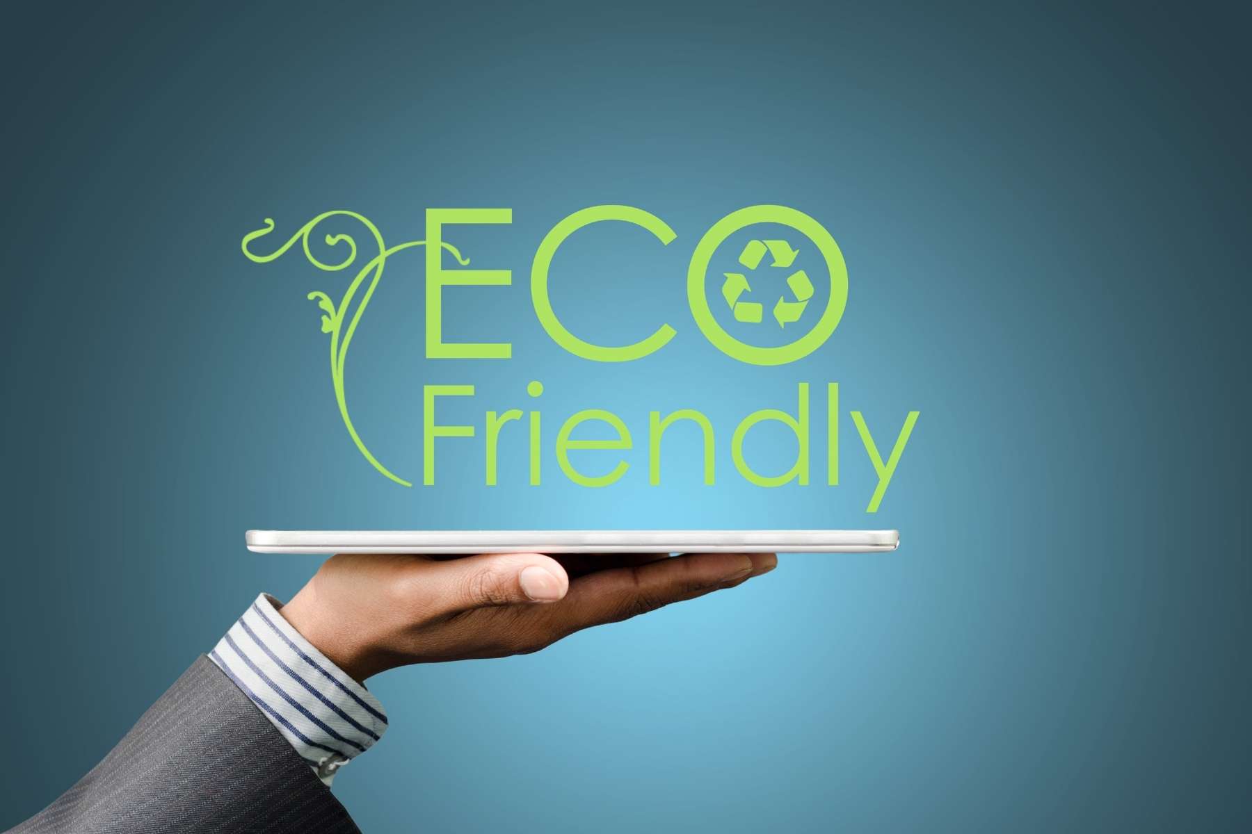 Eine Hand hält ein Tablet, über dem die Worte Ecofriendly in der Luft schweben, als Sinnbild für kreislauffähige Büros.