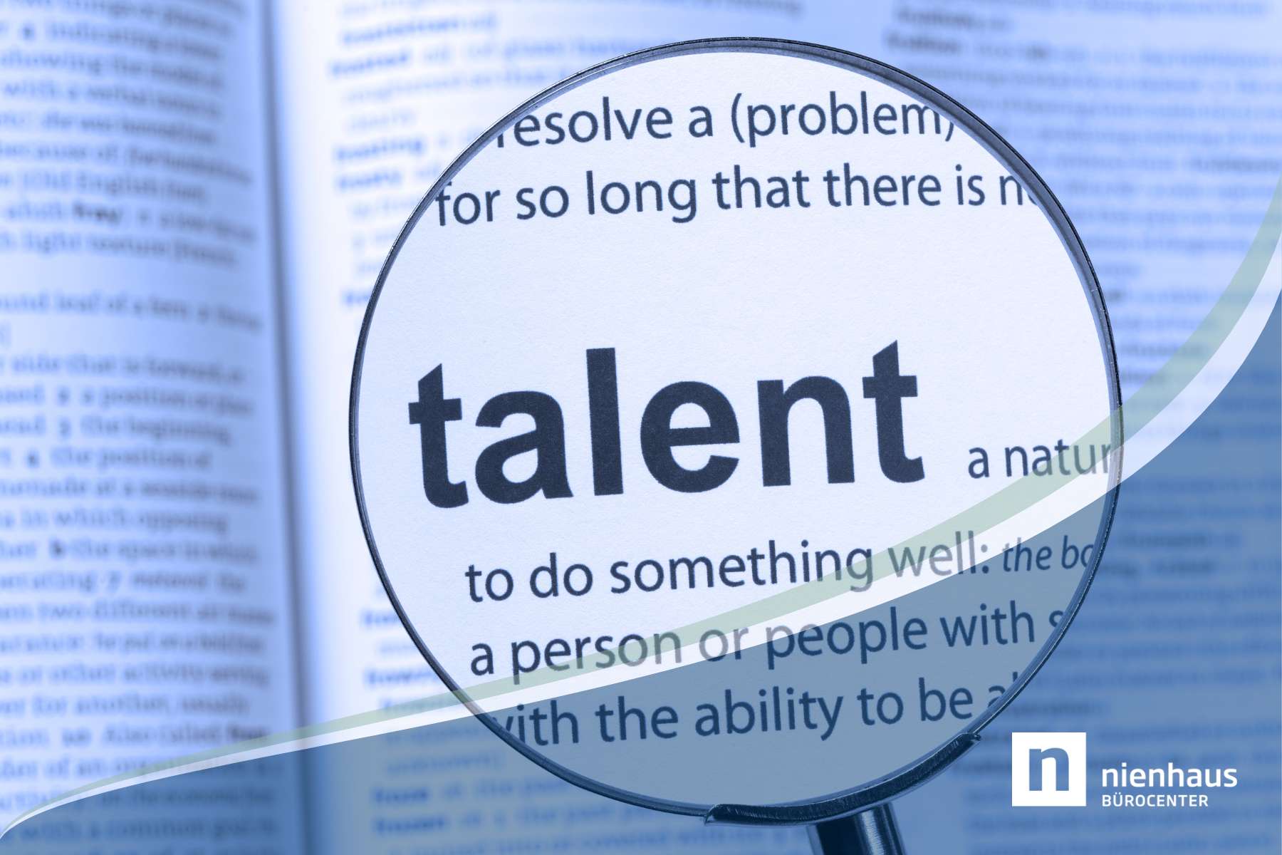 Eine Lupe ist auf ein Wörterbuch gerichtet und zeigt das Wort Talent und die dazugehörige Erläuterung.