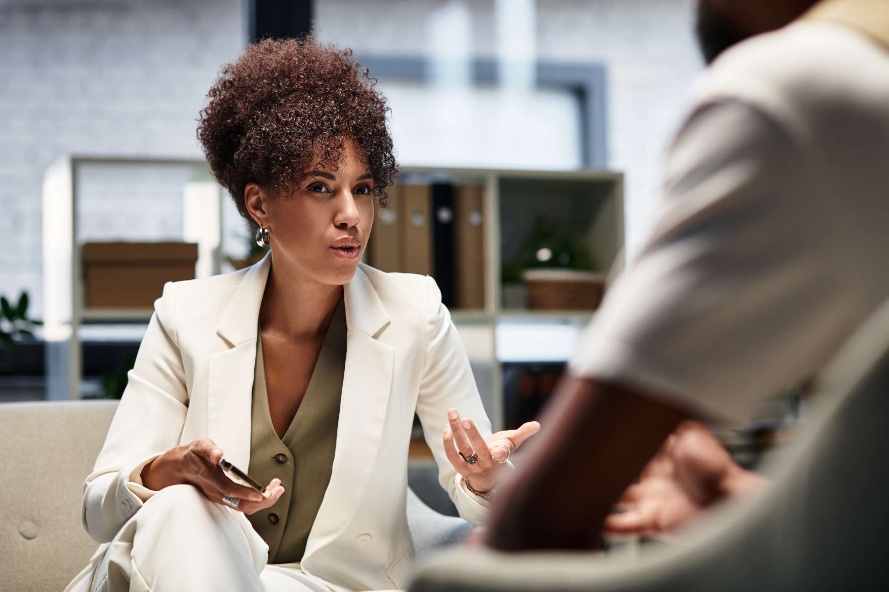 Eine junge schwarze Führungskraft ist im Gespräch mit einem männlichen Angestellten.