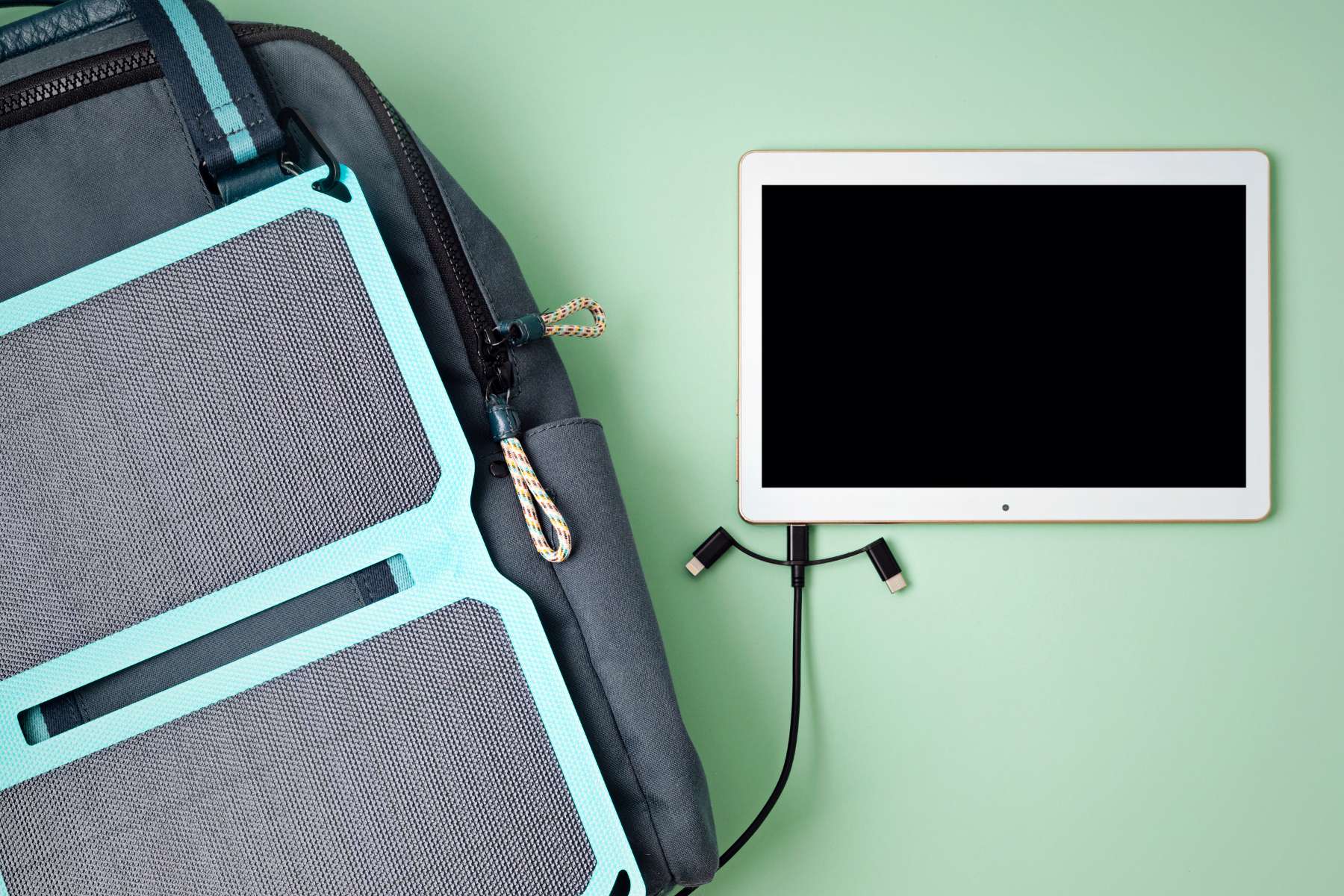 Rucksack mit Solar-Paneel, über das ein Tablet aufgeladen wird, als Gadget des Home-Office 2 Go.