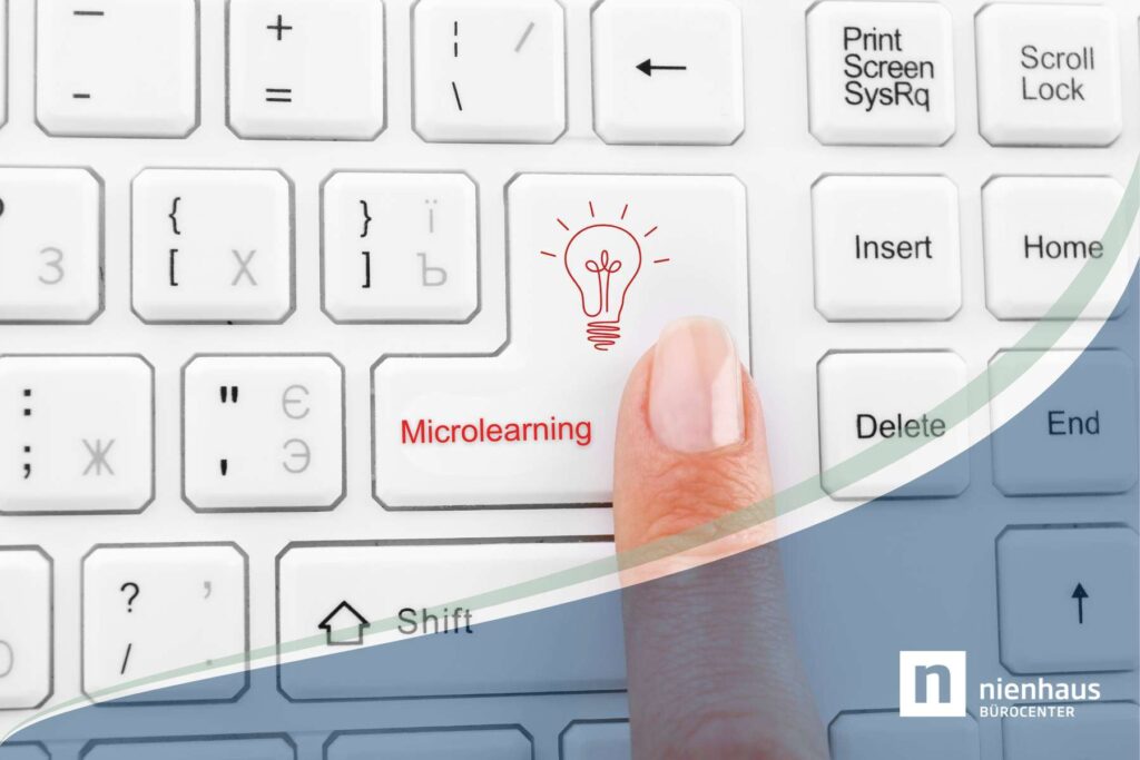 Ein Finger liegt auf einer weißen Tastatur und drückt eine Taste auf der in Rot das Wort Microlearning steht.