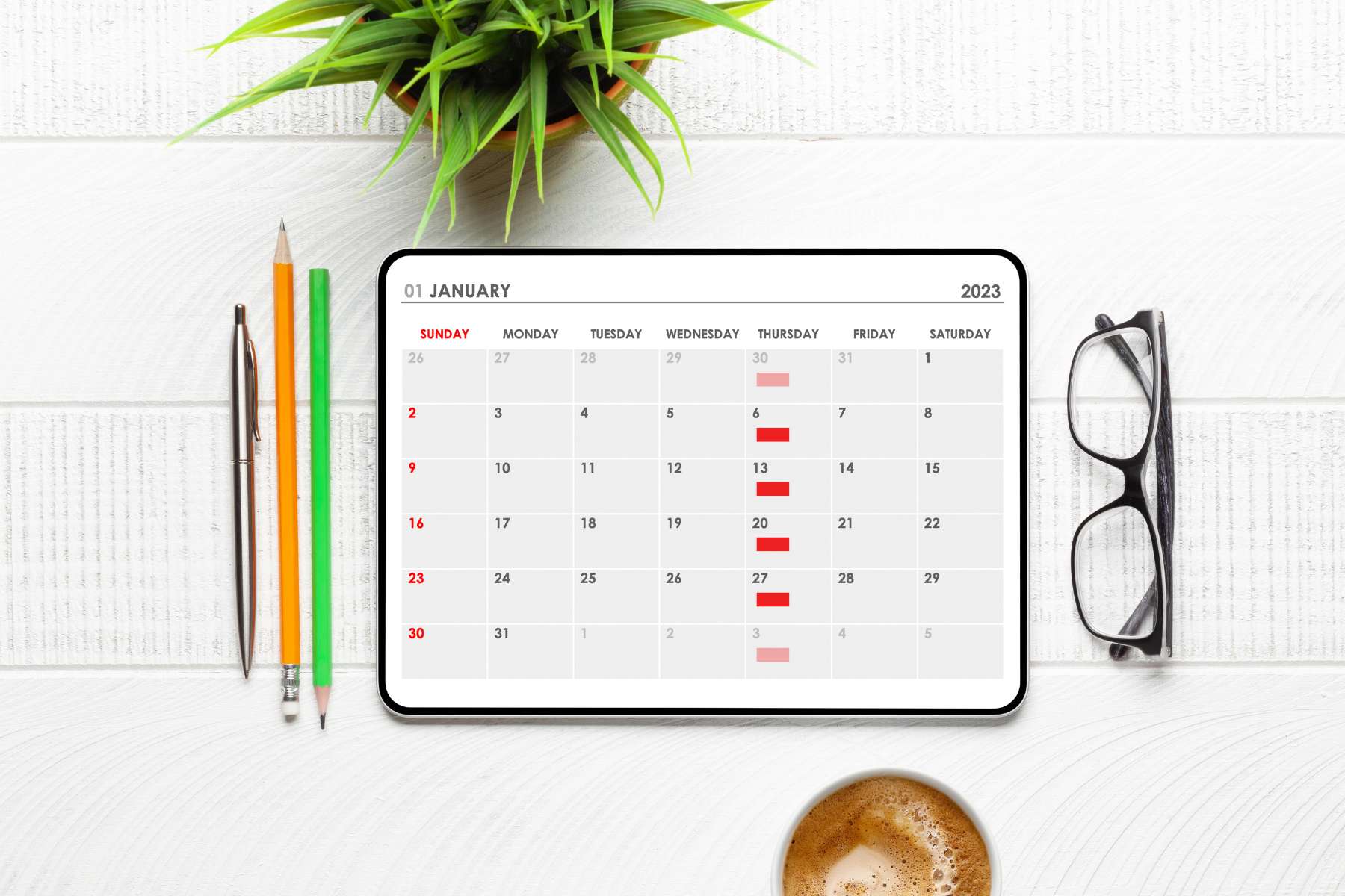 Auf einem Schreibtisch liegen Stifte, eine Brille und ein Tablet, auf dem ein Kalender zu sehen ist auf dem wöchentliche Termine zum Thema Microlearning im Büro eingetragen sind.