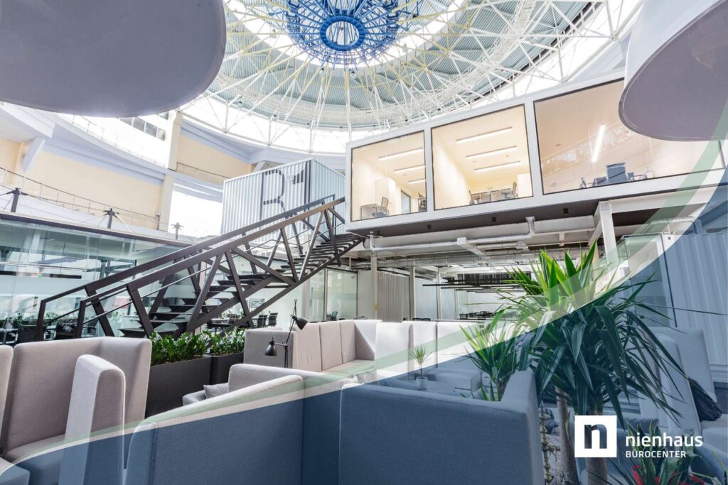 Moderner Büroraum mit Glas-Meetingboxen, Lounge-Bereich und offener Raumstruktur im New Work Stil