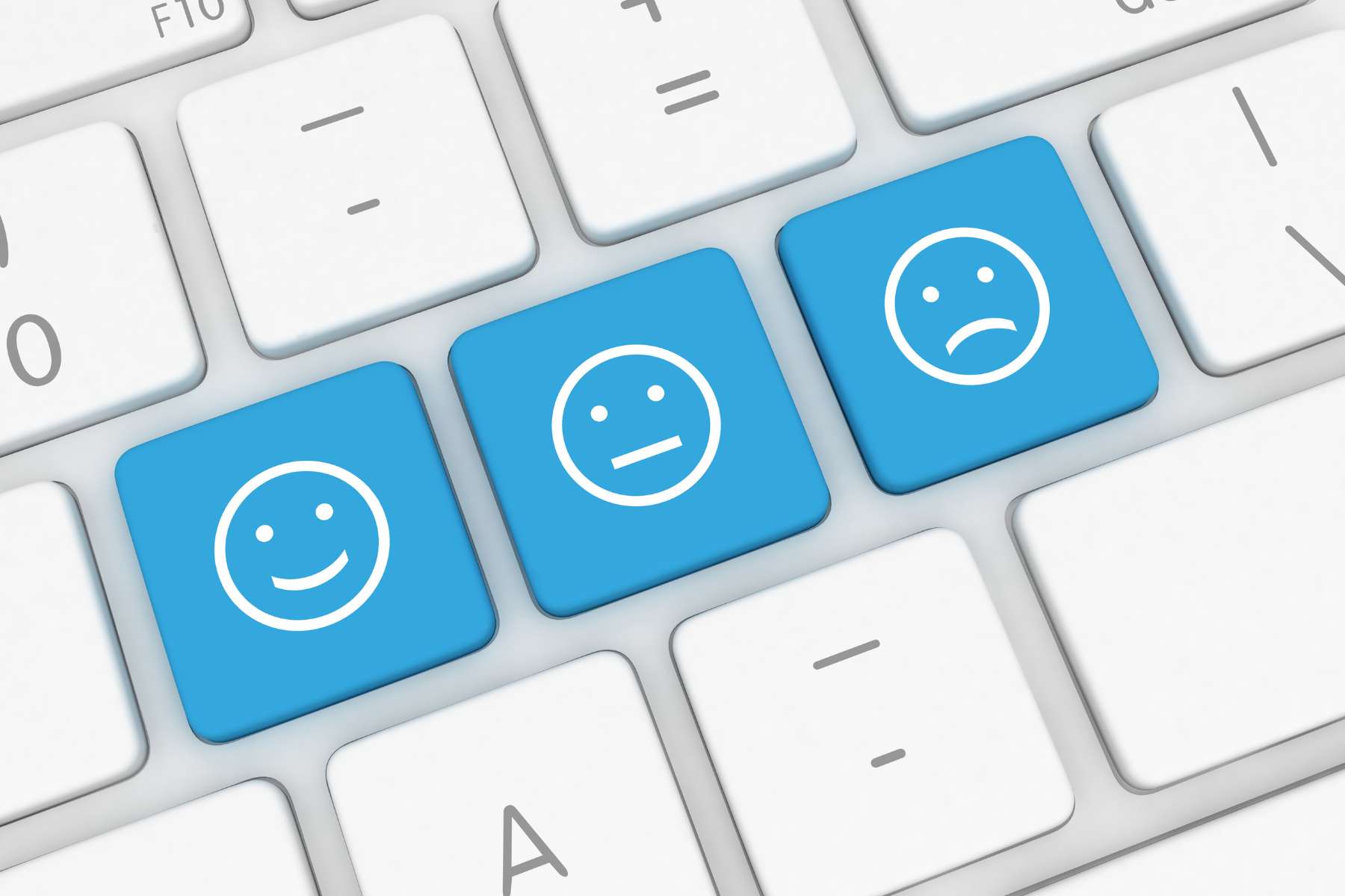 Eine weiße Tastatur mit drei blauen Tasten. auf denen je ein lächelndes, ein neutrales und ein schlechtgelauntes Gesicht abgebildet ist.