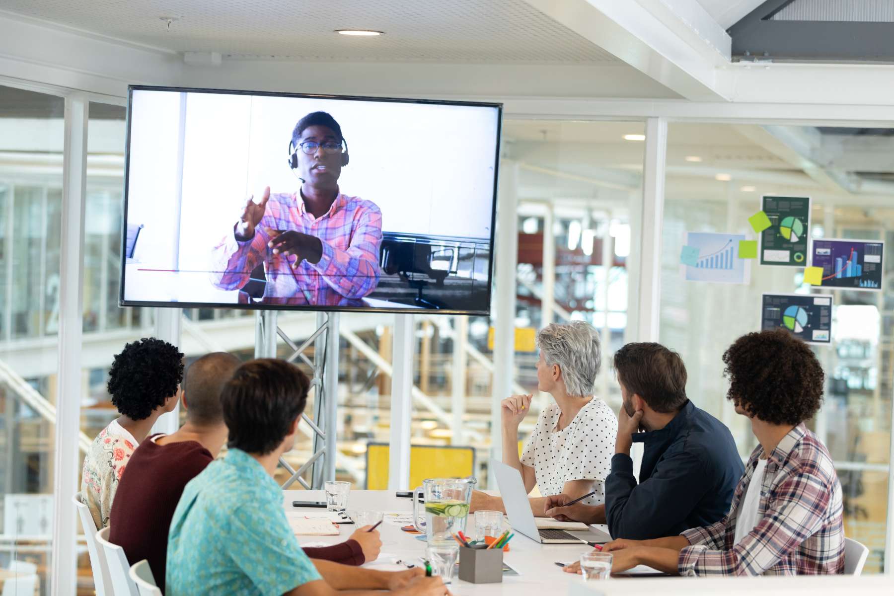 Hybrides Meeting im Smart Office mit Videokonferenz und internationalem Team.