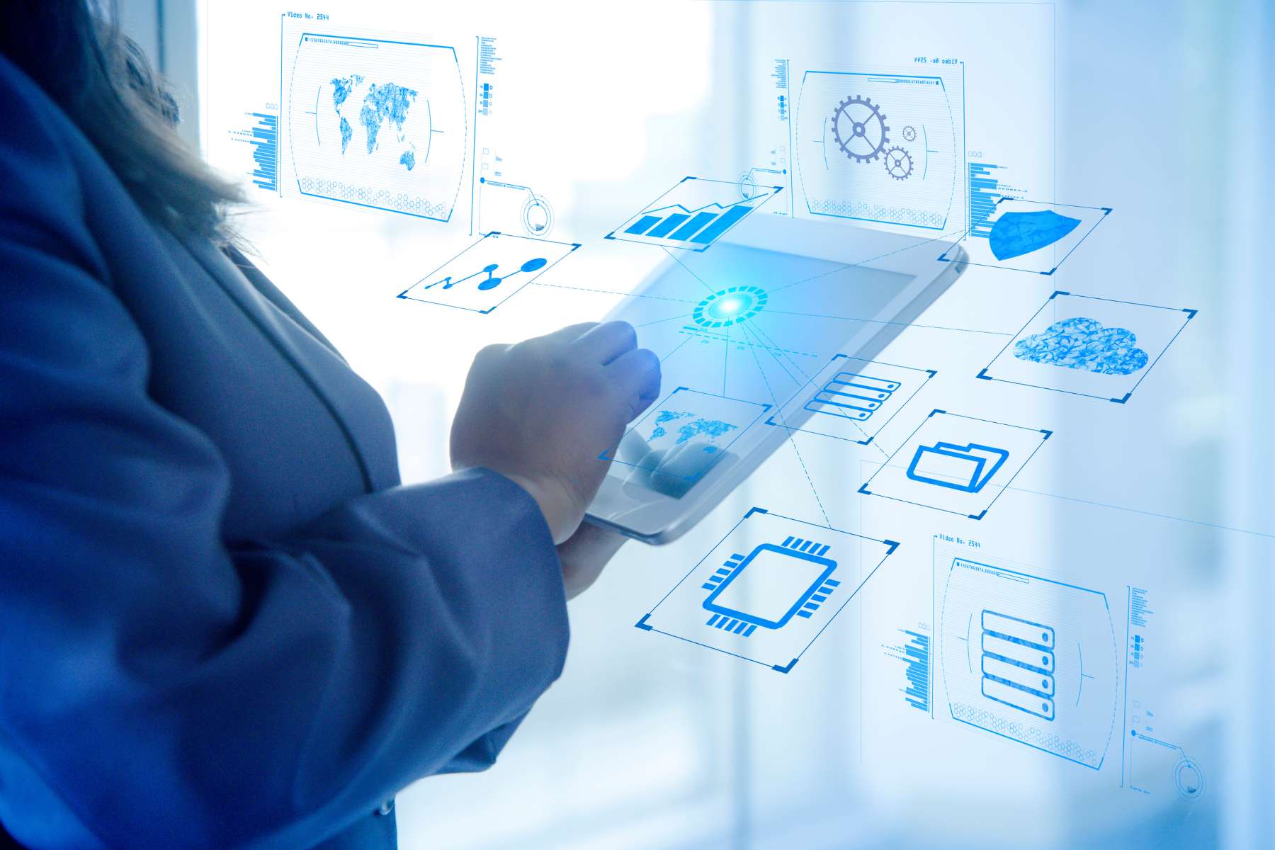Weibliche Mitarbeiterin arbeitet an Tablet und steuert über KI-gestützte Assistenzsysteme das Smart Office.